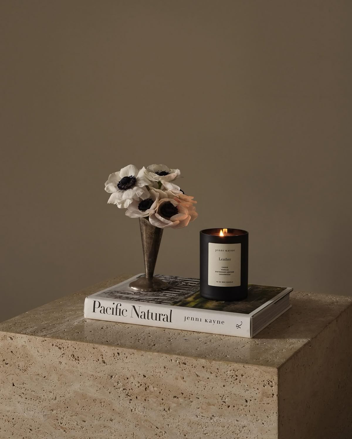 Luxury black candle and white flowers on book Pacific Natural, Moodie Saunter fragrance gift