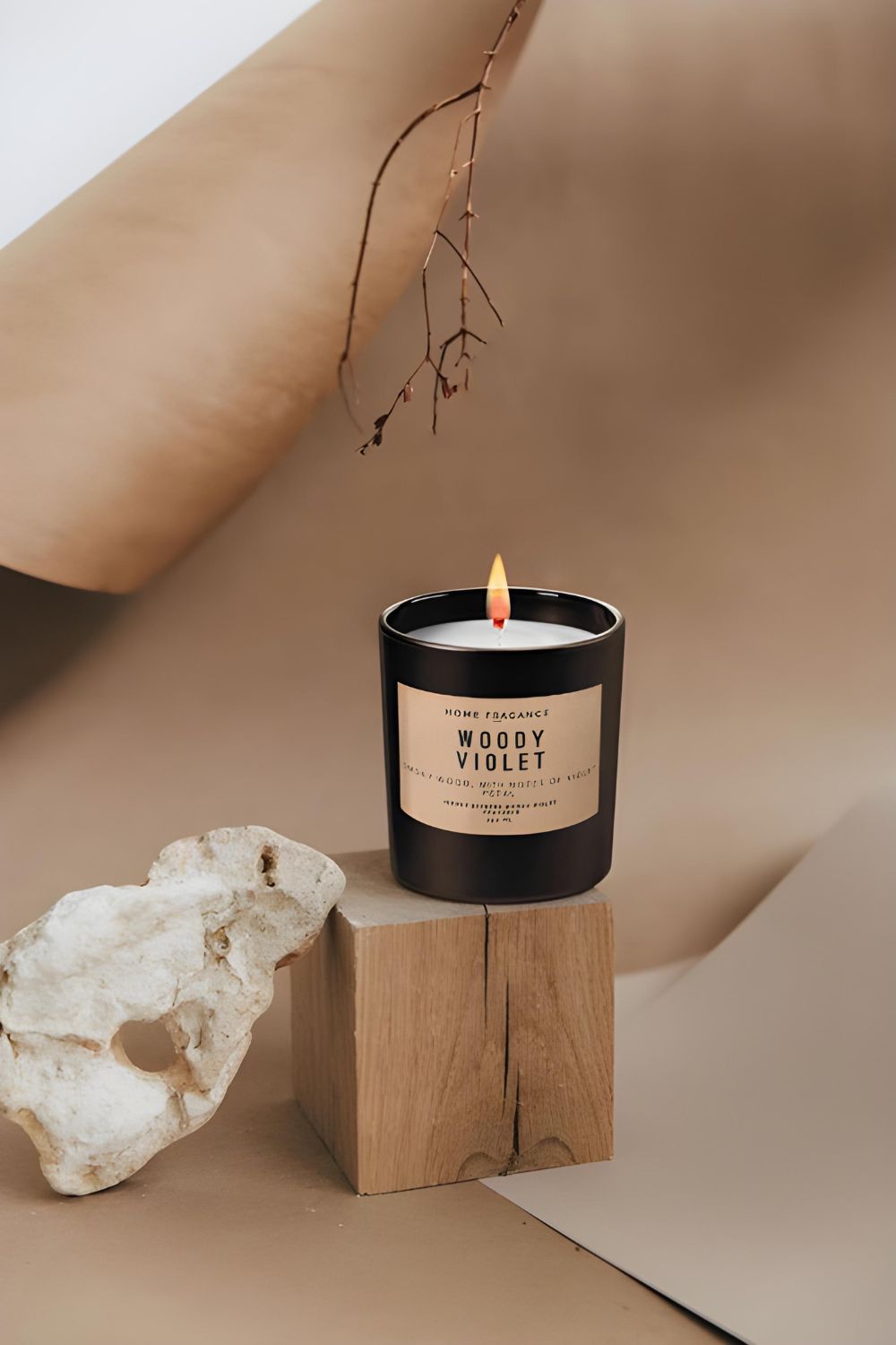 Woody Violet candle on wooden block with stone, minimal beige background, Moodie Saunter gift