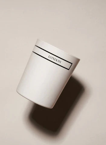Minimalist white candle jar labeled 'London', photographed on a neutral background for Moodie Saunter fragrance gifts.